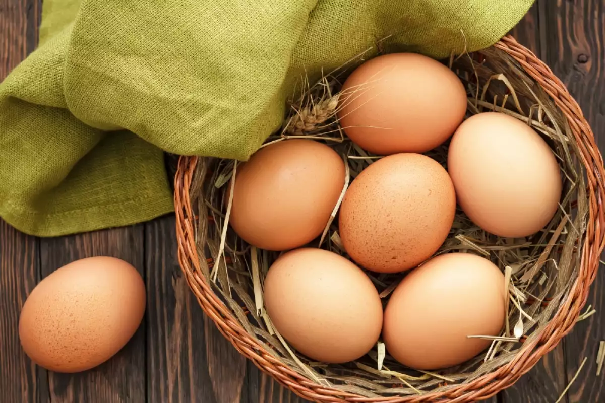 Basket of brown eggs with green cloth.