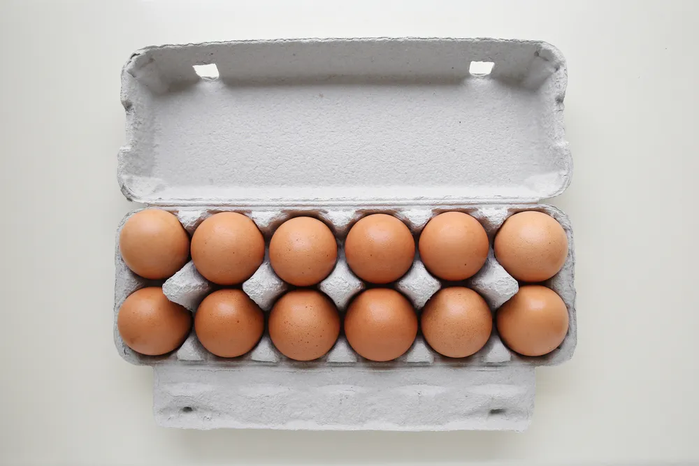 Carton of twelve brown eggs, open view.